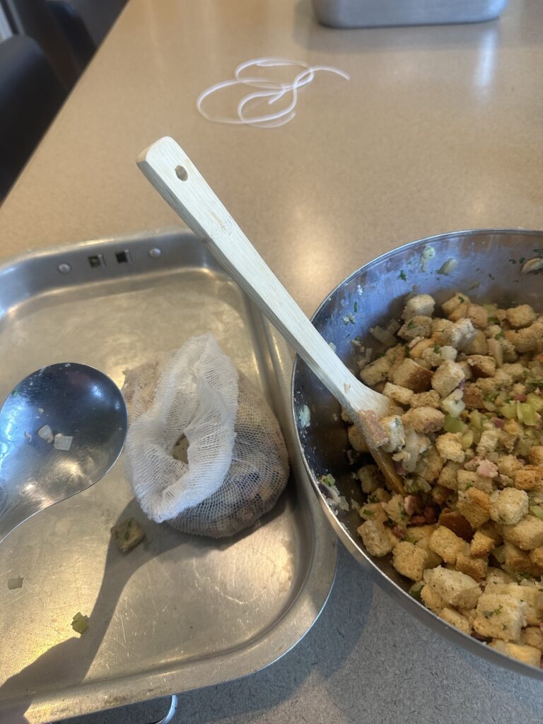 A photo of a partially filled stuffing bag next to a bowl containing the entire stuffing mixture.